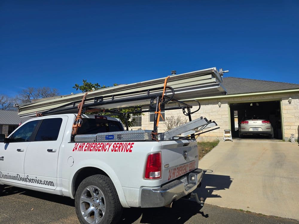 Pickup truck with ladder racks, parked outside a house for emergency service.