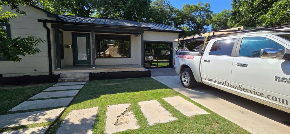 Modern house exterior with landscaped yard and service vehicle parked in driveway.